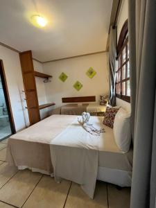 1 dormitorio con cama y ventana en Pousada do Marinho, en Búzios