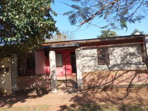 een huis met een rode deur en een hek bij Como en casa in Campo Grande