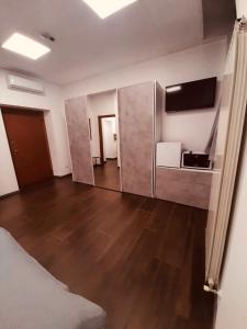 an empty room with a bed and a wooden floor at Maura's b&b in Gallarate