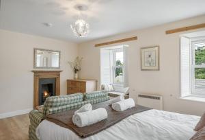 een slaapkamer met een bed, een bank en een open haard bij The Boy's Cottage in Portreath