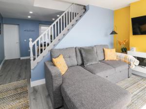 uma sala de estar com um sofá e uma escada em Jasmine Villa em Llandudno