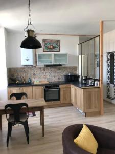 - une cuisine avec une table et un canapé dans une chambre dans l'établissement Superbe T2 dans un parc arboré, à Lamalou-les-Bains