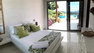 a bedroom with a large white bed with green pillows at Finca San Pedro in La Mesa