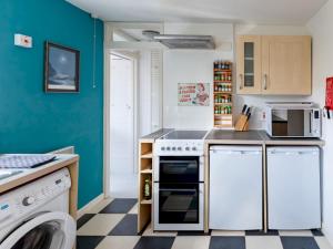 a kitchen with white appliances and a blue wall at Pass the Keys Cosy Cottage with Fireplace in Bridgwater