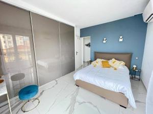 - une chambre avec un grand lit et un mur bleu dans l'établissement Beach front, Superbe appartement pour 4 personnes, à Nice