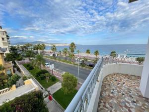 einen Balkon mit Blick auf eine Straße und das Meer in der Unterkunft Beach front, Superbe appartement pour 4 personnes in Nizza