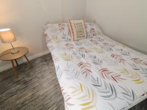 a bed in a room with a pillow and a lamp at Mulroy Cottage in Glinsk