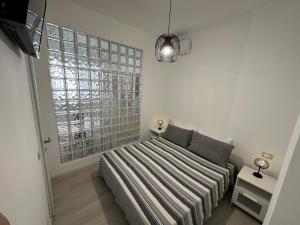 a bedroom with a bed and a large window at Monolocale Portoverde Beach in Misano Adriatico