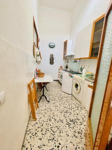 a small kitchen with a washing machine and a table at Casa Racchia in Porto Santo Stefano