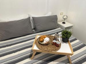 a coffee table with a tray of bread and mugs on a bed at Monolocale Portoverde Beach in Misano Adriatico