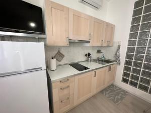 a kitchen with wooden cabinets and a white refrigerator at Monolocale Portoverde Beach in Misano Adriatico