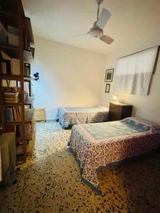 a bedroom with two beds and a book shelf at Casa Racchia in Porto Santo Stefano