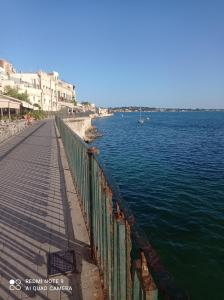 a walkway next to a body of water with buildings at Il Bungalow di Villa Mirko in Vaccarizzo - Delfino