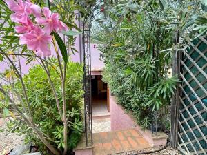 a mirror in a garden with pink flowers at Appartamento L'Oleandro in Capoliveri