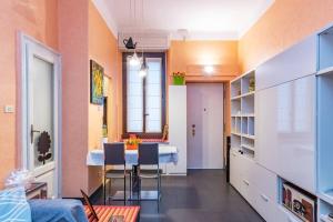uma sala de estar com uma mesa e cadeiras num quarto em [IHost Apartment] - Bassini 46 em Milão