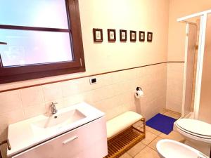 a bathroom with a sink and a toilet and a window at Appartamento L'Oleandro in Capoliveri