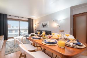 a dining room with a table with food and wine glasses at Cozy Sunny Flat w/ Terrace - São João in Porto
