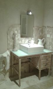 a bathroom with a sink and a mirror at Holiday Home Trullo Antico in Ostuni