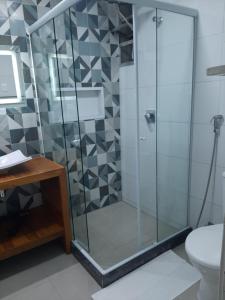 een glazen douchecabine in een badkamer met een toilet bij Estúdio na quadra da praia in Rio de Janeiro