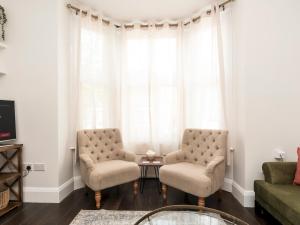 a living room with two chairs and a table at Pass the Keys Elegant Modern 2 Bed Flat Near Greenwich Park in London