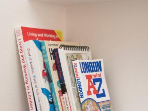 a row of books sitting on a shelf at Pass the Keys Elegant Modern 2 Bed Flat Near Greenwich Park in London