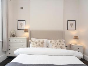 um quarto branco com 2 camas e 2 mesas de cabeceira em Pass the Keys Elegant Modern 2 Bed Flat Near Greenwich Park em Londres