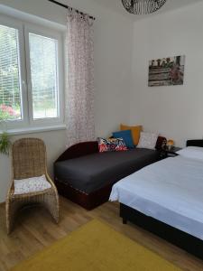 サーザヴァにあるStará Sázavaのベッドルーム1室(ベッド1台、ソファ、椅子付)
