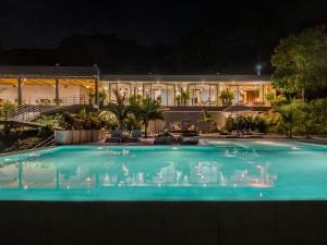 a swimming pool in front of a building at night at Santuario Luxury Eco Hotel in Villeta