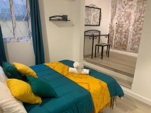 1 dormitorio con cama azul y manta amarilla en Sam & Chlo Studio & Appartment - Grand Baie - Mauritius, en Grand Baie