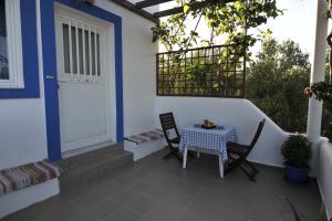 a patio with a table and chairs and a door at Nefeli Apartments in Kefalos