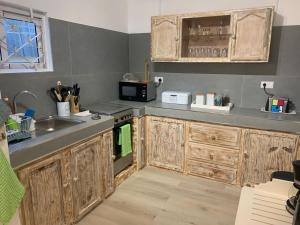 una cocina con armarios de madera y fregadero en Sam & Chlo Studio & Appartment - Grand Baie - Mauritius, en Grand Baie