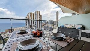 una mesa en un balcón con vistas a la ciudad en SUNSET WAVES sea view apartments en Benidorm