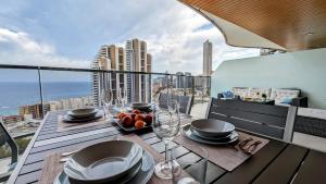 a table on a balcony with a view of the city at SUNSET WAVES sea view apartments in Benidorm