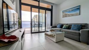 a living room with a couch and a table at SUNSET WAVES sea view apartments in Benidorm