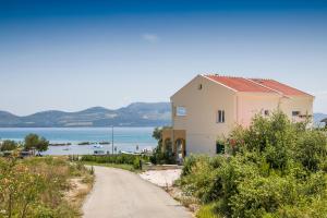 ein Haus an der Seite einer Straße neben dem Wasser in der Unterkunft Holiday home Nora in Drače