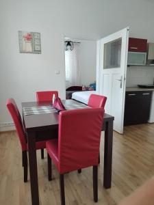 a dining room table with red chairs and a bedroom at Stará Sázava in Sázava