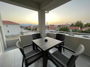 een tafel en stoelen op een balkon met uitzicht bij Lumi Apartments in Gevgelija