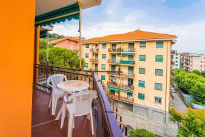 a balcony with a table and chairs and a building at 193 - Casa Via della Chiusa - centralissimo e vicino alla baia del silenzio, spiaggia e mare 150m - Parcheggio GRATIS incluso e Aria condizionata in Sestri Levante