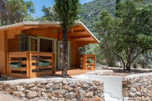 una pequeña casa de madera con un árbol delante en metaxaki cottage, en Mikros Gialos