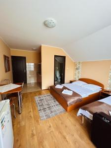 a bedroom with a bed and a table and a kitchen at Kelemen Vendégház 2 in Praid +70 photos