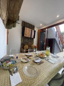 a dining room table with plates of food on it at Pousada Roots - D3 Experience - Préa, CE in Prea