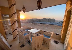 a table and chairs on a balcony with a view of the city at LuXury Apartment Nasr City - CityStars in Cairo
