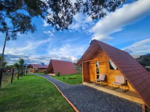 莱瓦镇Glamping El Muelle的沙砾路上带两把椅子的小木屋
