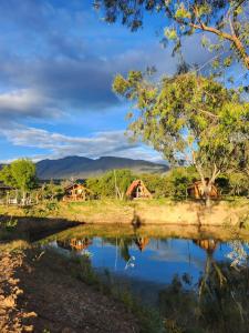 a view of a river with houses in the background at Glamping El Muelle in Villa de Leyva