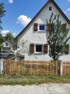 ein weißes Haus mit einem Holzzaun davor in der Unterkunft s´Paradies Ferienwohnung in Beilngries