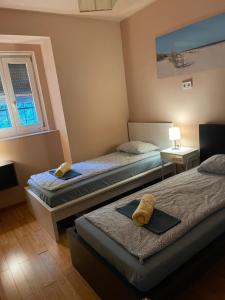 ブダペストにあるBudapest Gellért Apartmanのベッドルーム1室(ベッド2台、テーブル、窓付)
