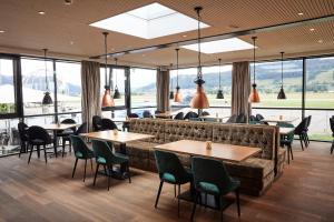 贝尔普AMANTE Hotel - Bern Airport的有桌椅和大窗户的餐厅