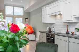 a kitchen with white cabinets and a vase of flowers at 5 Star - The Ulsterville Residences - Free On-site Parking in Belfast