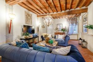 uma sala de estar com um sofá azul e uma mesa em Casa Kathy, Smart and Convenient Luxury 2 Bedrooms Apartment inside the City Walls em Lucca