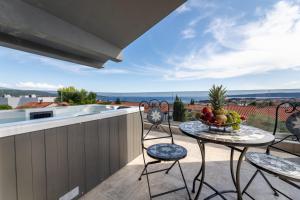 a table with a bowl of fruit on a balcony at Luxury Villa Adria Apartments in Krk